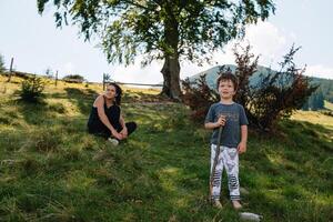 jong mam met baby jongen reizend. moeder Aan wandelen avontuur met kind, familie reis in bergen. nationaal park. wandeltocht met kinderen. actief zomer vakantie. vissenoog lens. foto