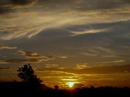 spectaculair zonsondergang over, oranje zon stijgende lijn omhoog over- de horizon foto