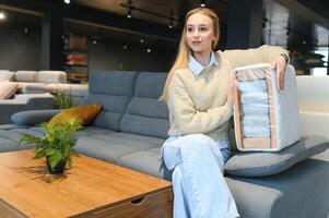 jong vrouw boodschappen doen voor meubilair, sofa en huis decor in op te slaan foto