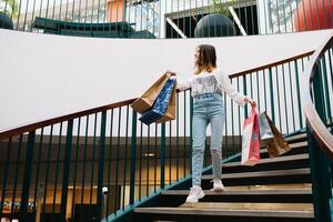 winkelen, geluk en mensen concept - glimlachen elegant tiener- meisje met boodschappen doen Tassen. boodschappen doen concept. foto