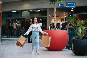 kleinhandel, gebaar en uitverkoop concept - glimlachen tiener- meisje met veel boodschappen doen Tassen Bij winkelcentrum. foto