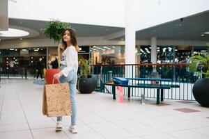 boodschappen doen tijd, detailopname van tiener- meisje poten met boodschappen doen Tassen Bij boodschappen doen winkelcentrum. foto