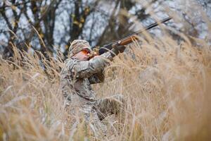 jacht- vergunning. Mens brutaal jachtopziener natuur achtergrond. jager besteden vrije tijd jacht. jager houden geweren. focus en concentratie van ervaren jager. jacht- en vangen seizoenen foto