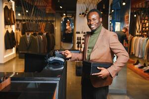 gelukkig Afrikaanse klant Holding dozen van nieuw kleren of schoenen en betalen met telefoon foto