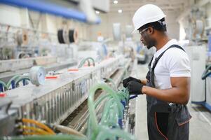 een Afro-Amerikaans mannetje arbeider in een plastic venster kader fabriek foto