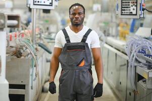 portret van Afrikaanse Amerikaans mannetje ingenieur in uniform en staand in industrieel fabriek foto