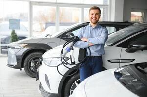 jong Mens buying eerste elektrisch auto in de toonzaal. eco auto uitverkoop concept foto