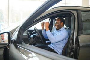 vrolijk zwart Mens zittend in luxe auto, test drijfveer, vervoer foto