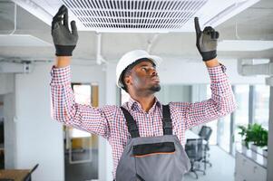 Afrikaanse mannetje technicus repareren lucht conditioner. foto