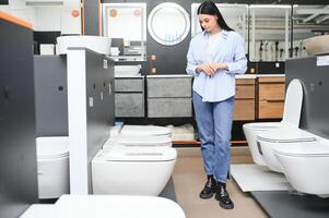 jong vrouw kiezen badkamer toilet kom en gereedschap voor zijn huis foto