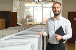 portret van een keramisch tegel verkoper. de verkoper staat tegen de achtergrond van een groot assortiment van tegels foto