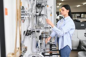 brunette vrouw op zoek kranen Bij loodgieter op te slaan foto