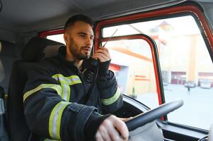 brandweerman gebruik makend van radio reeks terwijl het rijden brand vrachtauto foto