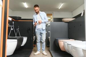in een loodgieter op te slaan, een Mens kiest een nieuw toilet kom foto
