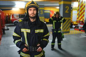 een brandweerman zet Aan een brand uniform Bij de brand afdeling foto