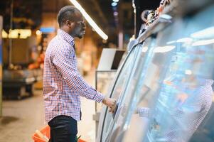 Afrikaanse Amerikaans Mens boodschappen doen in een supermarkt foto
