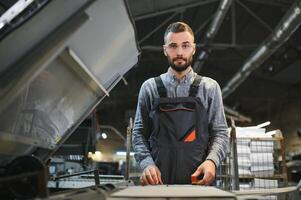 afdrukken arbeider proberen naar fix de probleem Aan computer naar bord machine in het drukken winkel foto