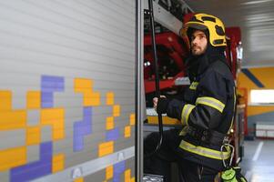 portret van mannetje brandweerman in uniform Bij brand station foto