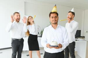 gelukkig bedrijf team met verjaardag taart en cadeaus groet Indisch mannetje collega Bij kantoor partij foto