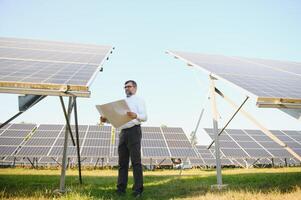 zonne- macht fabriek. Mens staand in de buurt zonne- panelen. hernieuwbaar energie foto