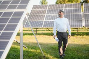 zonne- macht fabriek. Mens staand in de buurt zonne- panelen. hernieuwbaar energie foto