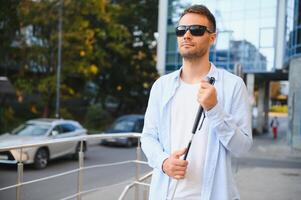 Blind Mens wandelen Aan trottoir Holding stok. foto