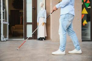 Blind Mens detailopname met een wandelen stok. wandelen naar beneden de straat foto