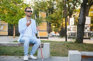 jong verblind Mens gebruik makend van telefoon en Bezig met verzenden stem bericht foto