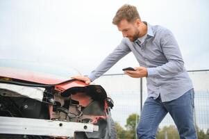 jong Mens bestuurder in auto ongeluk in de buurt gebroken auto Aan de weg na een auto ongeluk foto