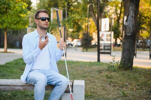 jong verblind Mens gebruik makend van telefoon en Bezig met verzenden stem bericht foto