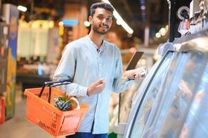 portret van Indisch mannetje in kruidenier met positief houding foto