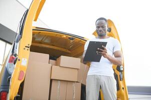 Afrikaanse mannetje post- levering koerier Mens in voorkant van auto leveren pakket foto