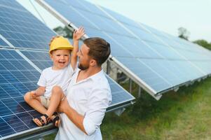 vader en zijn weinig zoon in de buurt zonne- panelen. foto