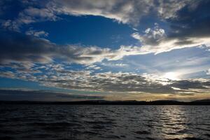 spectaculair zonsondergang over, oranje zon stijgende lijn omhoog over- de horizon foto