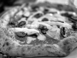 smakelijk pizza dichtbij visie achtergrond. zwart en wit pizza foto