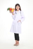 mooi jong Aziatisch vrouw dokter heeft een mooi glimlach. Holding een kom van vers biologisch groenten voedsel voor mooi zo Gezondheid. voorschrift voedsel voeding concept, gezond aan het eten. wit achtergrond. foto