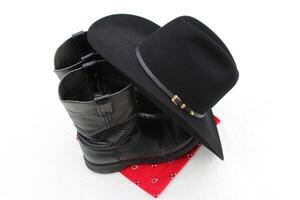 een zwart cowboy hoed, zwart cowboy laarzen en een rood bandana. foto