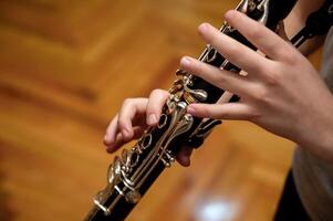 dichtbij omhoog van kinderen handen spelen de klarinet in een muziek- studio foto