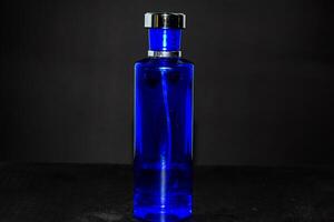 transparant donker blauw fles parfum geïsoleerd zwart achtergrond voor bespotten omhoog ontwerp foto