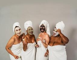 gelukkig multiraciaal Dames met verschillend leeftijden en lichaam grootte hebben huid zorg spa dag - mensen welzijn en zelf zorg concept foto