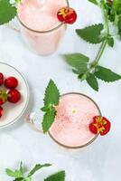 milkshake met aardbeien in een glas glas met melissa bladeren in de ontwerp, top visie foto