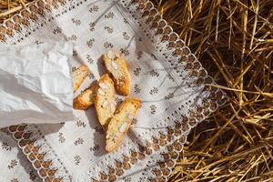 amandel koekjes crackers met stukken van noten viel uit van een papier zak Aan een servet aan het liegen Aan de rietje, top visie foto