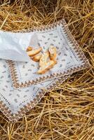 amandel koekjes crackers met stukken van noten liggen Aan een servet tegen de achtergrond van rietje. een tussendoortje in natuur foto