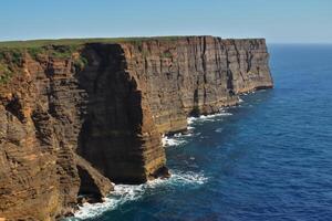 kust majesteit adembenemend kust- kliffen ontmoeten verbijsterend blauw zee, een schouwspel van van de natuur grootsheid foto