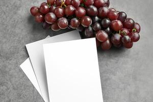 wit papier mockup verbeterd door de sappig verleiden van vers druiven, bouwen een zichtbaar symfonie van culinaire elegantie en gezond beeldspraak, waar grafisch ontwerp bloeit in een feest van levendig creativiteit foto