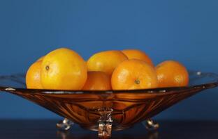 een glas kom met mandarijnen foto