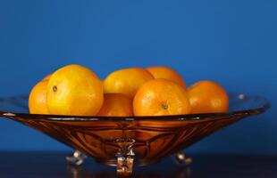 een glas kom met mandarijnen foto