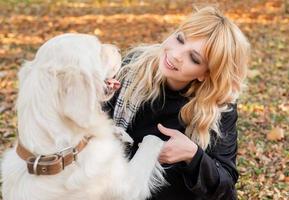 een mooie vrouw met haar labrador retriever-hond die in het park ligt foto