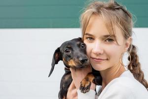 portret van tiener die haar teckel-huisdier knuffelt