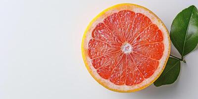 voor de helft van een vers grapefruit met een groen blad Aan een wit achtergrond, ruimte voor tekst. foto